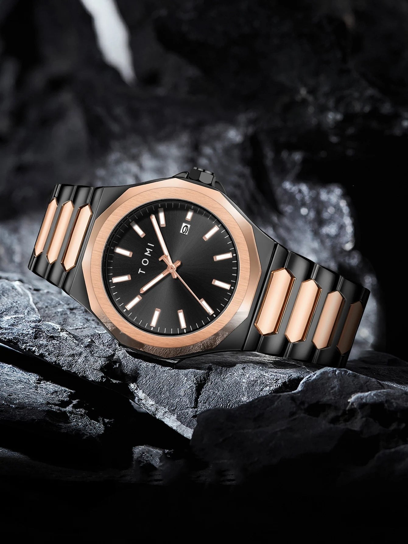 My Store TOMI luxury stainless steel wristwatch in black and rose gold resting on a dark textured stone surface.
